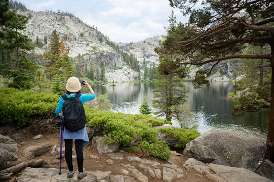 Woman taking photos of Eagle lake using smartphone. South Lake Tahoe. California.