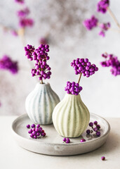 Beautiful floristic arrangement with  purple beauty berry branches in mini ceramic vases. Romantic...