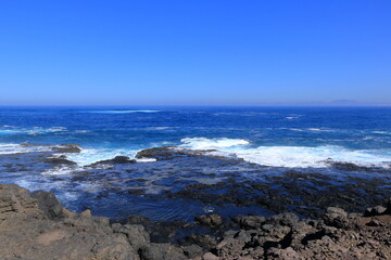 Stormy waves breaking on the stony beach in Fuerteventura in Jandia Natural Park