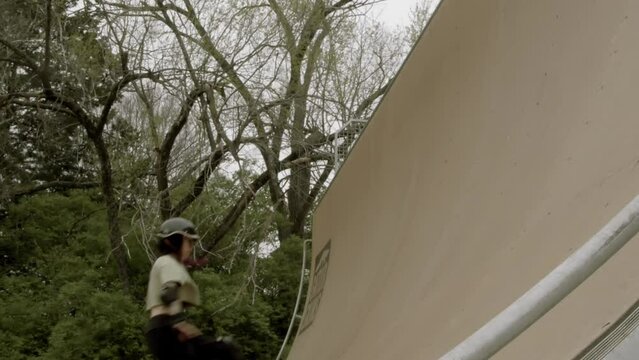 Roller skater is skating on Corey Lawrence halfpipe in Lawrence Kansas on an overcast day