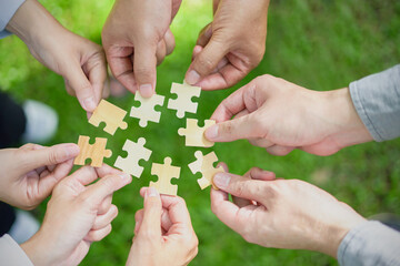  business hands holding jigsaw puzzle With the cooperation of business people team joins together to campaign Environment, Society and Corporate Governance. Sustainable corporate social, environmental