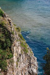 Cliffside next to the dark blue sea at the amlfi coast in italy.