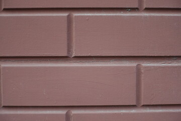 Macro of reddish brown painted brick veneer wall