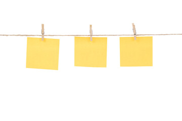 Wooden clothespins with blank notepapers on twine against isolated white background space for text. note blank color paper cards on rope. blanks for designers
