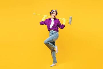 Full body young fun woman wears purple shirt casual clothes do housework tidy up hold in hand broom...