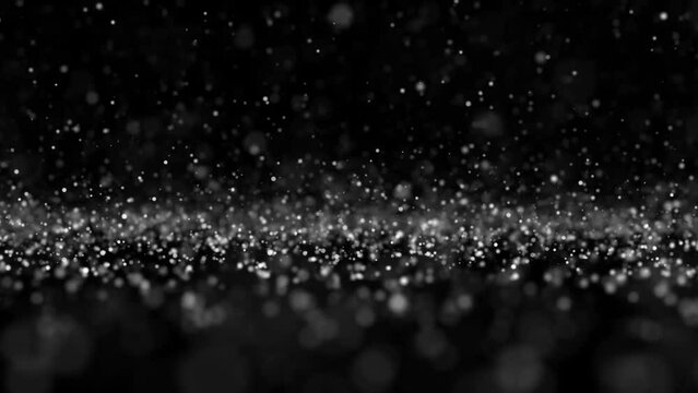 Falling sparkling particles on a black background