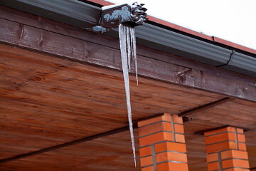 Huge icicle hanging from a roof gutter