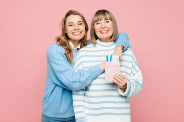Traveler two woman parent mom, adult daughter wear casual clothes hold passport ticket hug isolated on plain pink background. Tourist travel abroad in free time rest getaway. Air flight trip concept. - 775739103