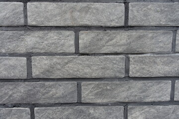 Closeup of gray artificially aged brick veneer wall
