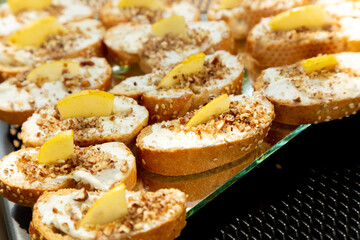 Canapes and Cocktail Snacks: Crostini with Cream Cheese, Apple Slices and Dried Fruits Appetizer - Catering Food in Outdoor Banquet Table
