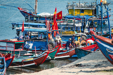 Fototapeta na wymiar Vietnamese Fishermen at Work. Traditional Vietnamese fishing boats.