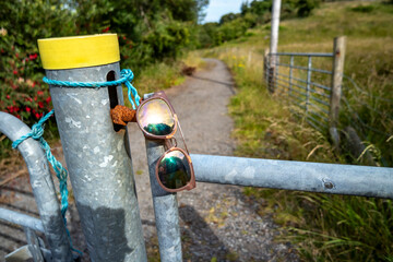 Sun glasses resting on a gate in rural Ireland