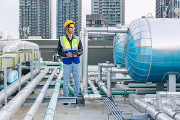 engineer male technician worker working service hotel boiler tank hot water supply pipe system. man...