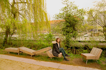 Naklejka na ściany i meble Person sitting on a bench in the park.