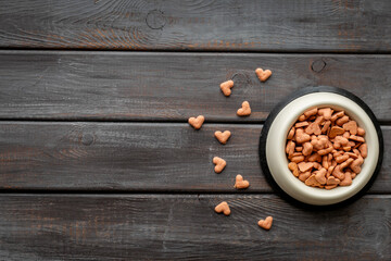 Bowl of biscuits for pets - food in a shape of heart, top view