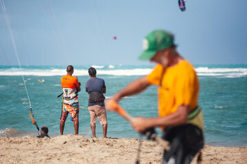 Active sporty people enjoying kitesurfing holidays and activities on perfect sunny day on Cabarete tropical sandy beach in Dominican Republic.