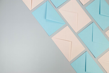 Top view of pink and blue envelopes on grey background. Colourful envelopes wallpaper, post flat...