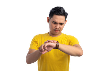 Handsome young Asian man checking time on his watch with serious facial expression isolated on white background