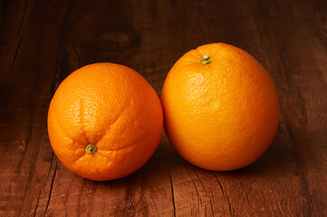 나무 테이블 위에 2개의 오렌지가 놓여 있다