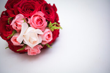 Wedding bouquet of the bride in red tones is on a white  chair. Flowers for wedding reception.
