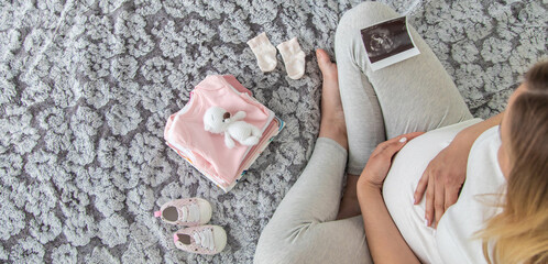 A pregnant woman collects baby things. Selective focus.