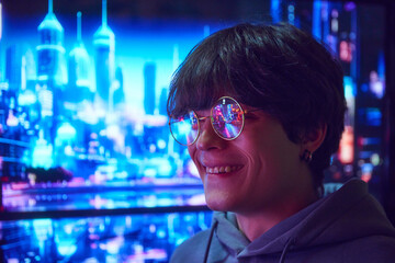 Young guy standing in glasses with urbane scene reflecting in eyewear. Night city with lights, skyscrapers and lively streets. Concept of emotions, urban lifestyle