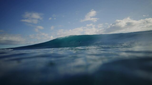 Turquoise blue water at ocean surface as wave breaks into deep barrel