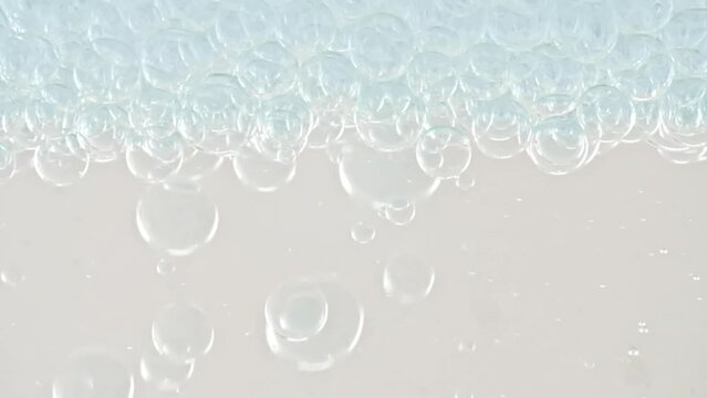 Macro Shot of Different Sized Clear Air Bubbles in Clear Water Rising up on White Background. Body Care Cosmetics Concept. Essence, Liquid Bubble, Molecule. Slow Motion . High quality FullHD footage