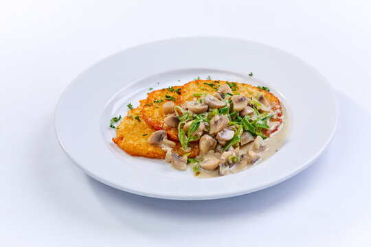 potato pancakes  with mushrooms on white plate