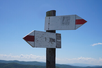Wooden signpost with two arrows - tourist trail