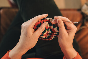High angle view of a woman's hands crocheting a rug