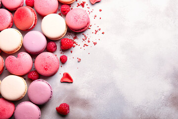 A collection of heart-shaped cookies neatly arranged on a pink background. Cookies of different sizes and decorated with colorful icing.