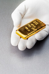 man hand holding a gold bar, close up.