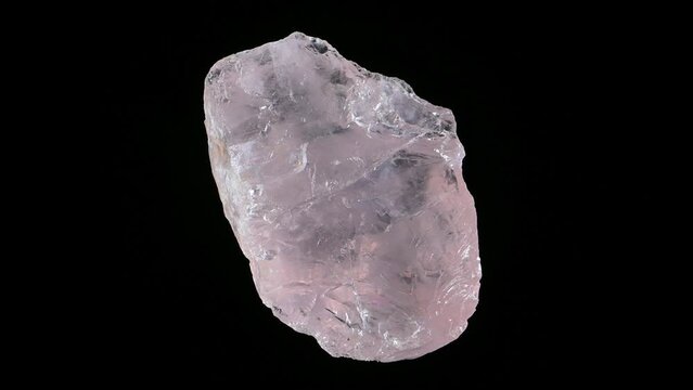 Rose quartz crystal rotating slowly against a black background.