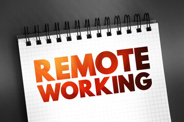 Remote Working - employment arrangement in which employees do not commute to a central place of work, such as an office building, warehouse, or retail store, text on notepad concept background