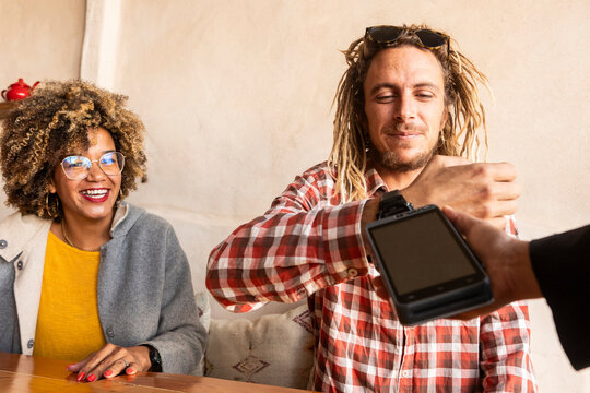 Joyful Friends Sharing Payment at a Cozy Bar