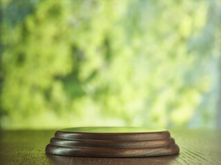 Round Wooden podium on Textured Table with Green Blurred Background