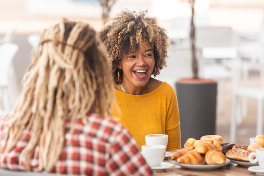 Friends sharing laughter over coffee and pastries