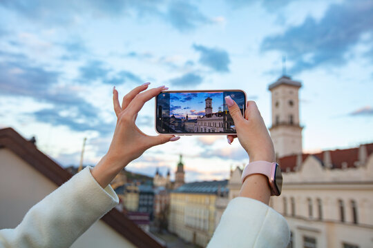 Female hands holding smartphone and making photos in Lviv