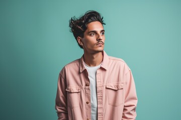 Obraz premium A man in a pink jacket is standing in front of a blue wall
