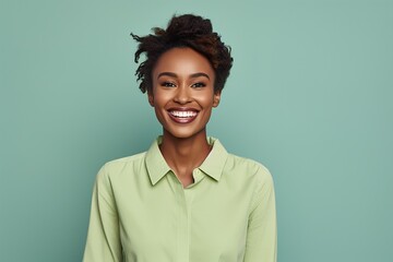 A woman with a green shirt is smiling and looking at the camera