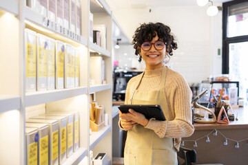 Small business owner using tablet in boutique shop