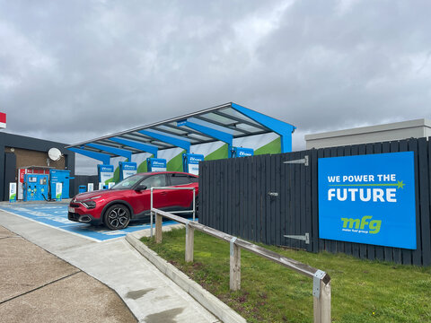Bexhill-Sussex-UK- April 3, 2024- An Electric Vehicle charging station shows several bays and a vehicle being charged