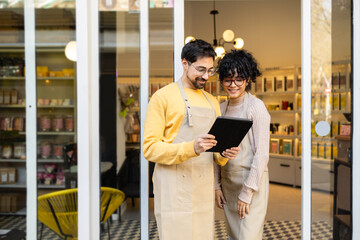 Small business owners using tablet in boutique shop