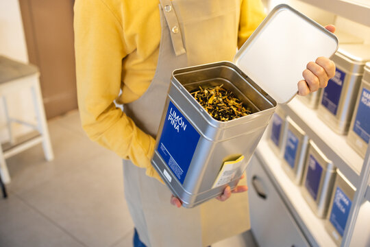 Person opening a bulk bin full of tea at store