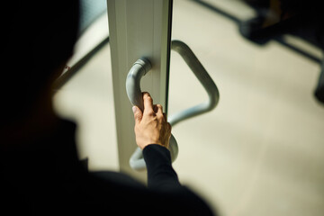 Photo of a female hand opening a door to the office.