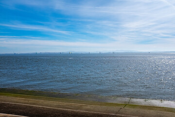 Coastview with blue sky and sailing boats in Lisbon Portugal