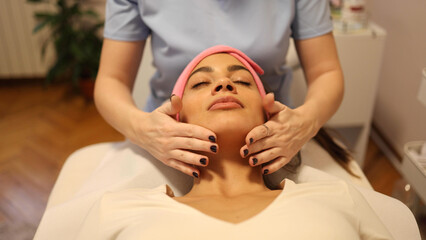 Obraz na płótnie Canvas Beautiful woman having a face massage treatment