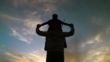 happy family child kid baby girl plays on her father shoulders sunset, father child silhouette, sunset family moments, childhood adventure fun, fatherhood bonding experience, dad son sunset, family - obrazy, fototapety, plakaty