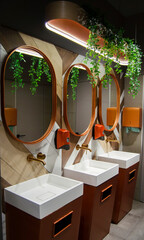 Three oval mirrors with wash basins, containers for liquid soap and paper towels. Beautiful...
